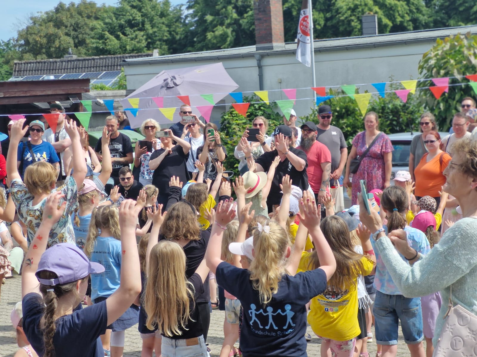 Viele Kinder und Eltern tanzen beim TadS-Sommerfest im Freien
