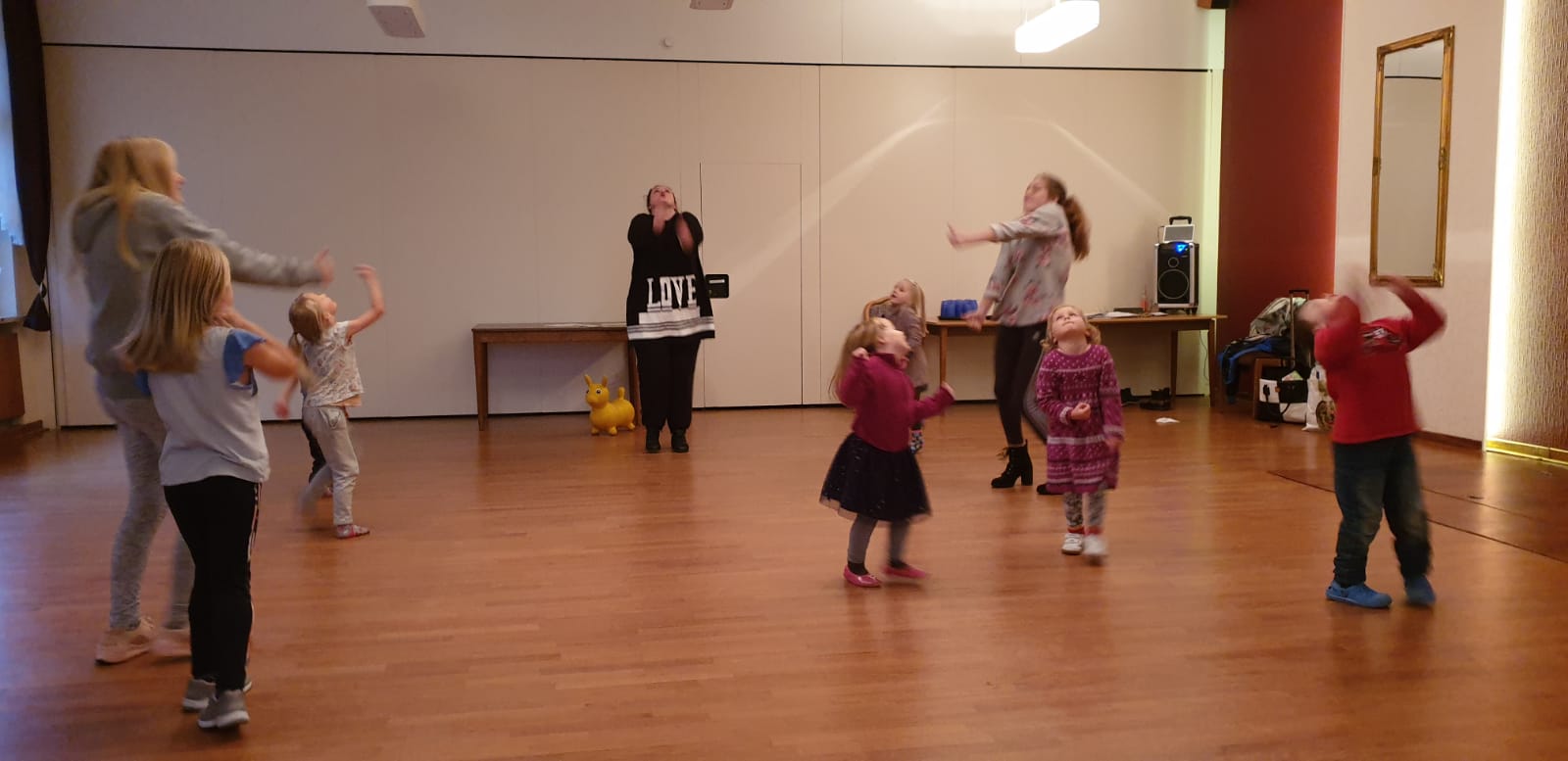 Kinder und Erwachsene tanzen gemeinsam im Saal