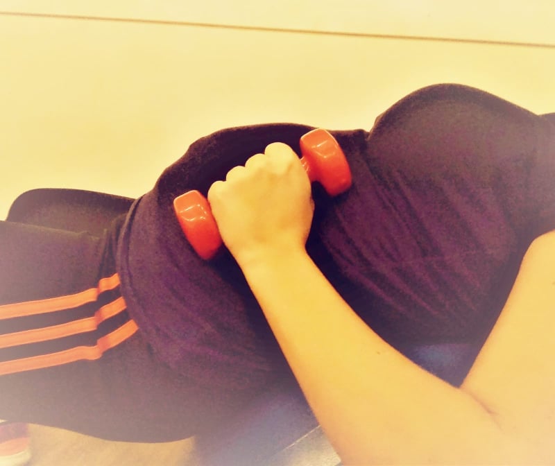 Schwangere beim sanften Fitnesstraining mit Hanteln