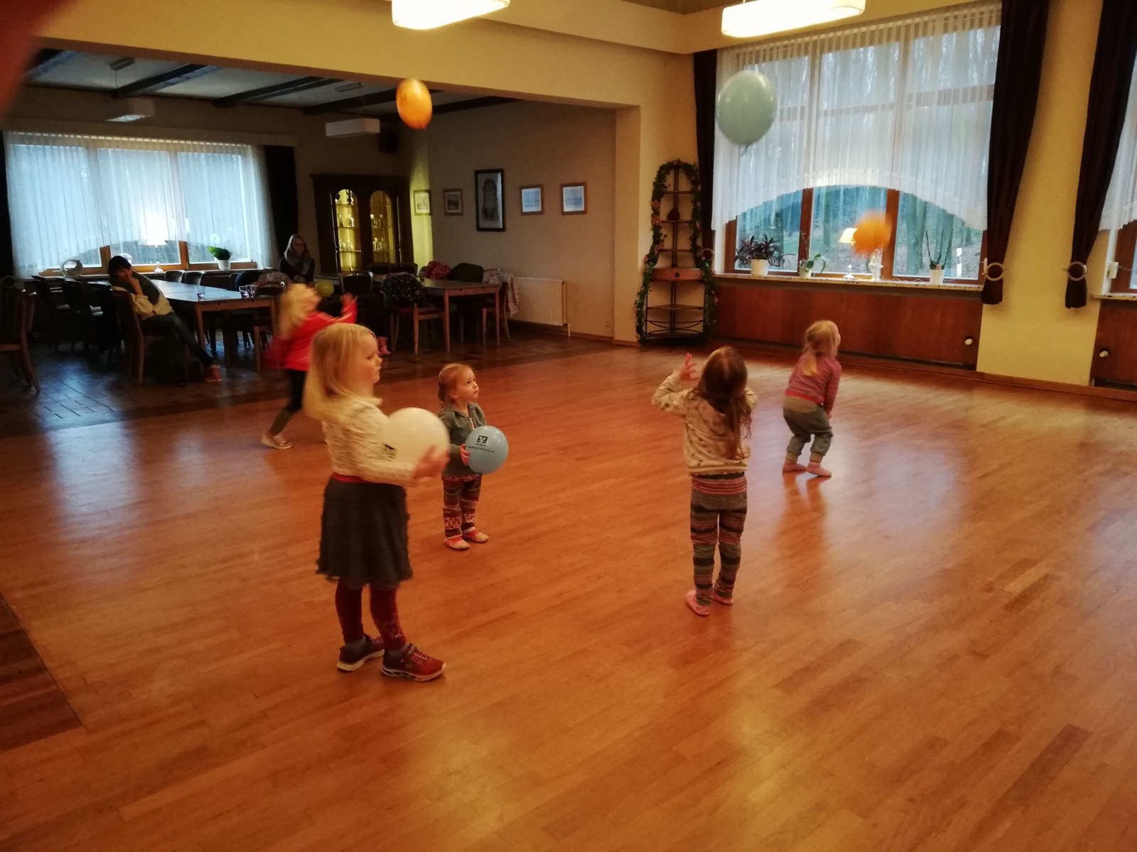 Kleine Kinder tanzen mit Luftballons im Saal
