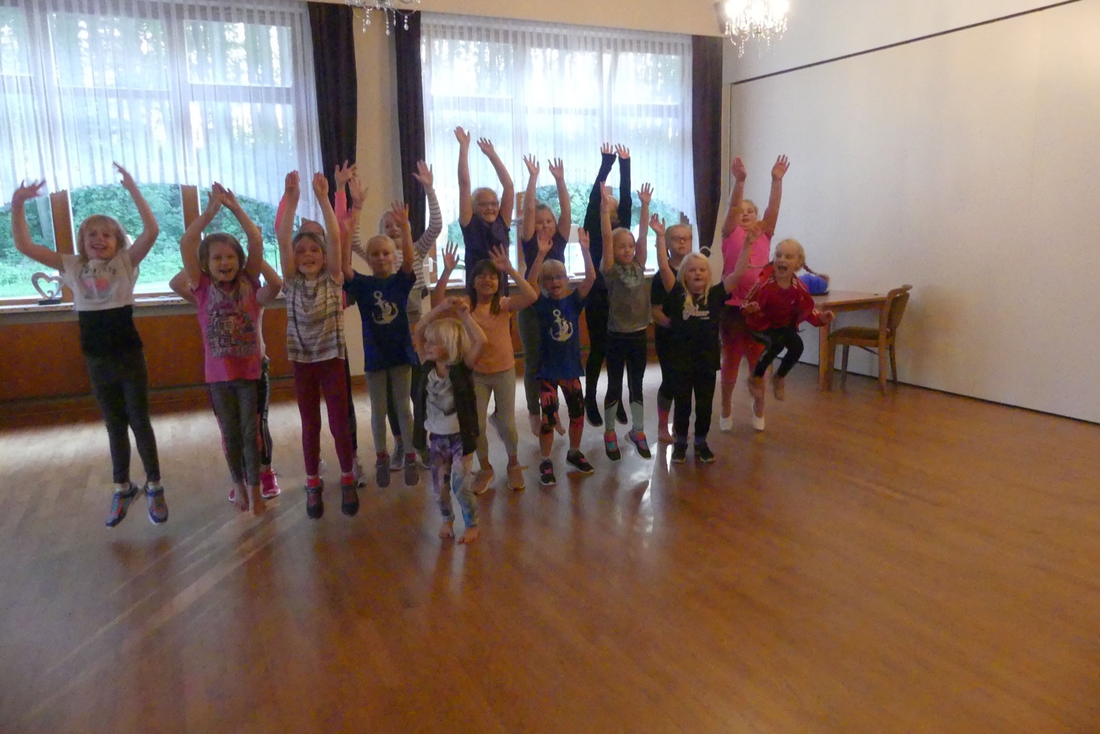 Eine Kindergruppe springt beim Tanztraining in die Luft
